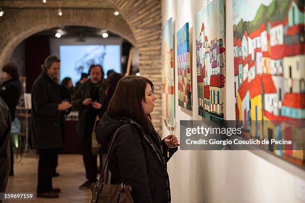 Visitors attend the opening of the exhibition of the paintings of the Mafia turncoat Gaspare Mutolo at Baccina 66 on January 18, 2013 in Rome, Italy.