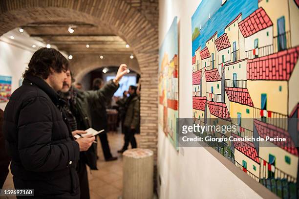 Visitors attend the opening of the exhibition of the paintings of the Mafia turncoat Gaspare Mutolo at Baccina 66 on January 18, 2013 in Rome, Italy.
