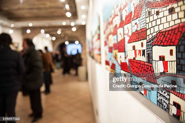 Visitors attend the opening of the exhibition of the paintings of the Mafia turncoat Gaspare Mutolo at Baccina 66 on January 18, 2013 in Rome, Italy.