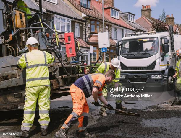 construction worker laying down tarmac - diversion stock pictures, royalty-free photos & images