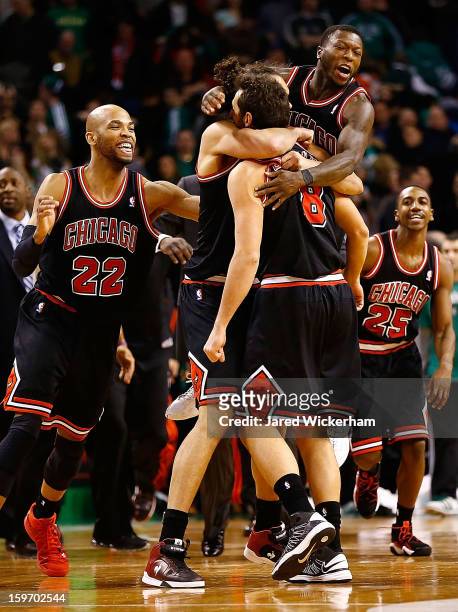 Marco Belinelli of the Chicago Bulls is embraced by teammates Joakim Noah and Nate Robinson of the Chicago Bulls after scoring the game-winning shot...
