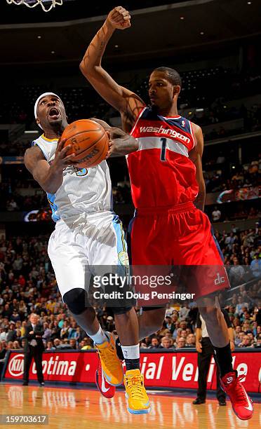 Ty Lawson of the Denver Nuggets lays up a shot against Trevor Ariza of the Washington Wizards at the Pepsi Center on January 18, 2013 in Denver,...