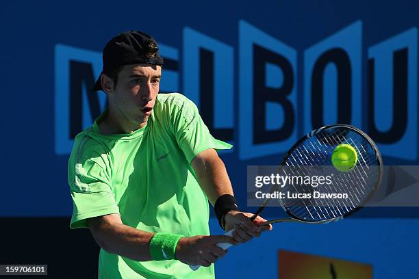 Nikola Milojevic of Serbia plays a backhand in his first round match against Jurence Zosimo Mendoza of Philippines during the 2013 Australian Open...