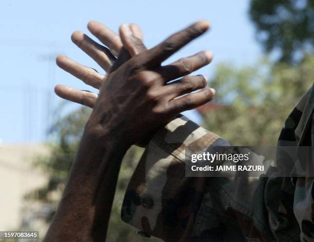 Haitian civilian shakes hands with a rebel near the presidential palace 01 March 2004 in Port-au-Price. Thousands welcomed Haitian rebels who made a...