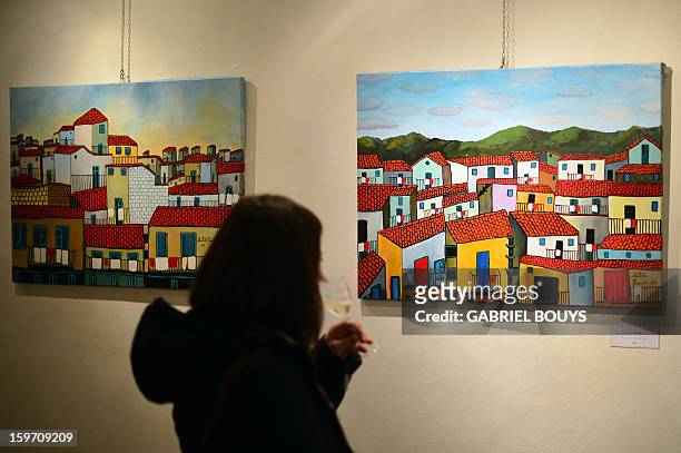 Visitor looks at a painting by Italian artist and former killer and drug trafficker for the Cosa Nostra mafia, Gaspare Mutolo, during the opening of...