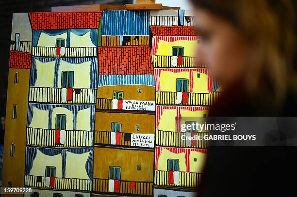 Visitor looks at a painting by Italian artist and former killer and drug trafficker for the Cosa Nostra mafia, Gaspare Mutolo, during the opening of...