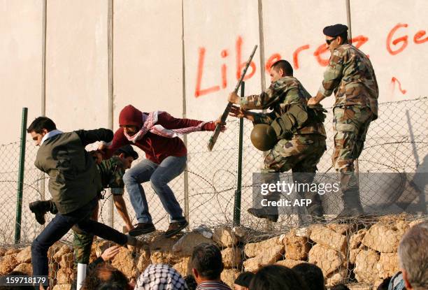 Lebanese army's soldiers prevent protestors from writing in French "Free Georges Abdallah" on a wall during a demonstration to call for his release...