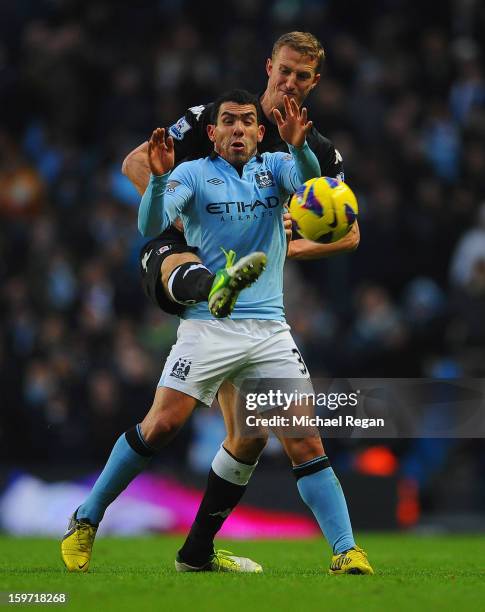 Brede Hangeland of Fulham in action with Carlos Tevez of Man City during the Barlcays Premier League match between Manchester City and Fulham at the...