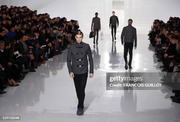 Models display creations by Belgian designer Kris Van Assche for the label Dior during the men's Fall-Winter 2013-2014 collection show on January 19,...