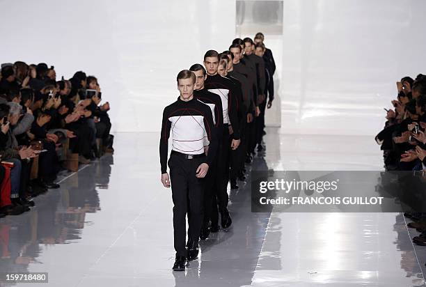 Models display creations by Belgian designer Kris Van Assche for the label Dior during the men's Fall-Winter 2013-2014 collection show on January 19,...