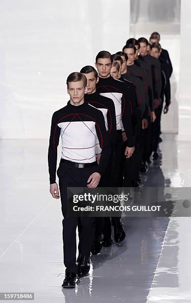 Models display creations by Belgian designer Kris Van Assche for the label Dior during the men's Fall-Winter 2013-2014 collection show on January 19,...