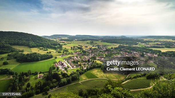 aerial view of the small village of voiteur surrounded by agricultural fields with the château-châlon (chateau chalon) aoc vines in the foreground. jura, franche comte (franche-comté), eastern france. - leonard field stock pictures, royalty-free photos & images