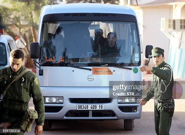 Algerian security forces escort a bus carrying freed hostages outside a police station in In Amenas in the desert in Algeria's deep south on January...