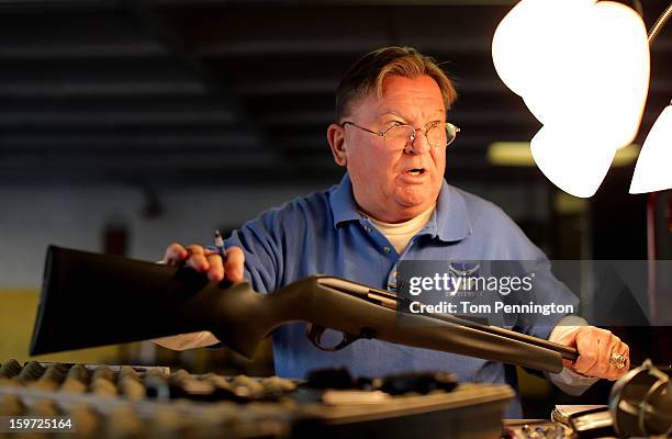 First Presbyterian Church of Dallas volunteer Mike Haney logs the serial number of an unloaded rifle that was being turned in during a gun buy back...