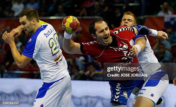 Serbia's pivot Alem Toskic vies with Slovenia's left wing Luka Zvizej and Slovenia's pivot Matej Gaber during the 23rd Men's Handball World...
