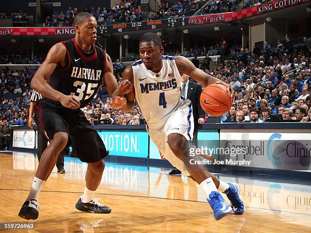 Adonis Thomas of the Memphis Tigers drives the baseline against Agunwa Okolie of the Harvard Crimson on January 19, 2013 at FedExForum in Memphis,...