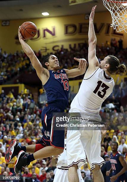 Nick Johnson of the Arizona Wildcats goes up for a shot against Jordan Bachynski of the Arizona State Sun Devils during the college basketball game...