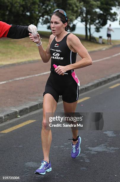 Annabel Luxford of Australia runs past a drink station during the Ironman 70.3 Auckland triathlon on January 20, 2013 in Auckland, New Zealand.