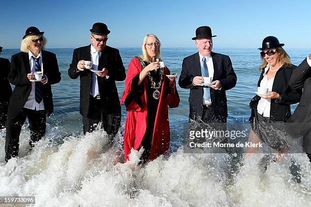 Participants stand in the water in suits and bower hats as part of an art installation created by surrealist artist Andrew Baines on January 20, 2013...