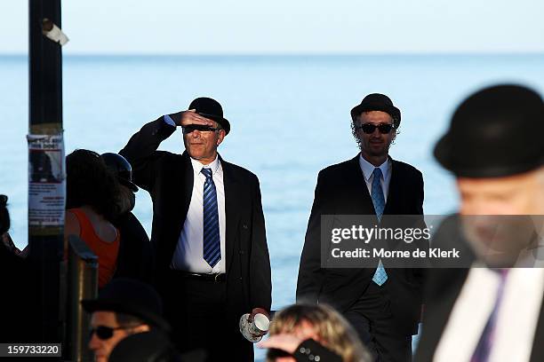 Participants wait before moving onto the beach dressed in suits and bowler hats as part of an art installation created by surrealist artist Andrew...