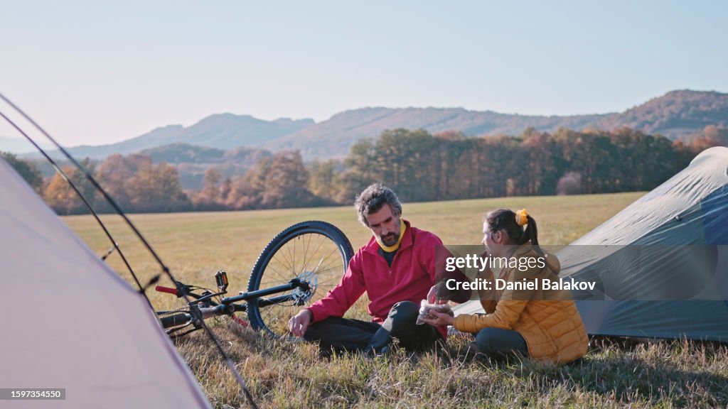 Ciclismo de montaña y acampada en tienda de campaña en la naturaleza al atardecer. Paseo en bicicleta en otoño.