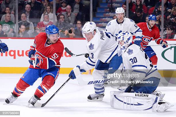 David Desharnais of the Montreal Canadiens and Dion Phaneuf of the Toronto Maple Leafs watch the loose puck in front of Ben Scrivens during the NHL...