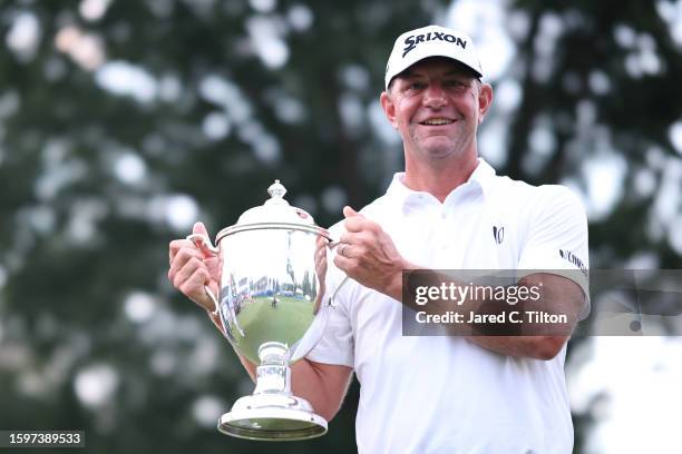 Lucas Glover of the United States poses with the championship trophy after winning the Wyndham Championship at Sedgefield Country Club on August 06,...