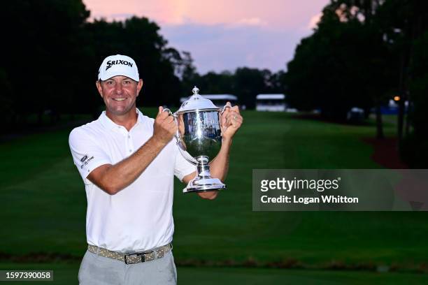 Lucas Glover of the United States poses with the championship trophy after winning the Wyndham Championship at Sedgefield Country Club on August 06,...