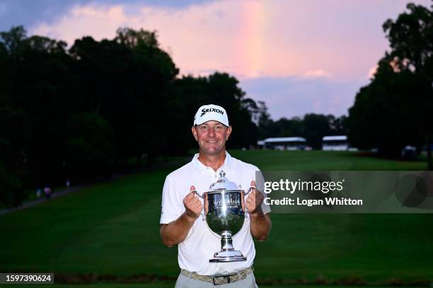 Lucas Glover of the United States poses with the championship trophy after winning the Wyndham Championship at Sedgefield Country Club on August 06,...