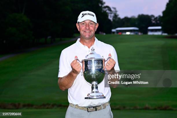 Lucas Glover of the United States poses with the championship trophy after winning the Wyndham Championship at Sedgefield Country Club on August 06,...