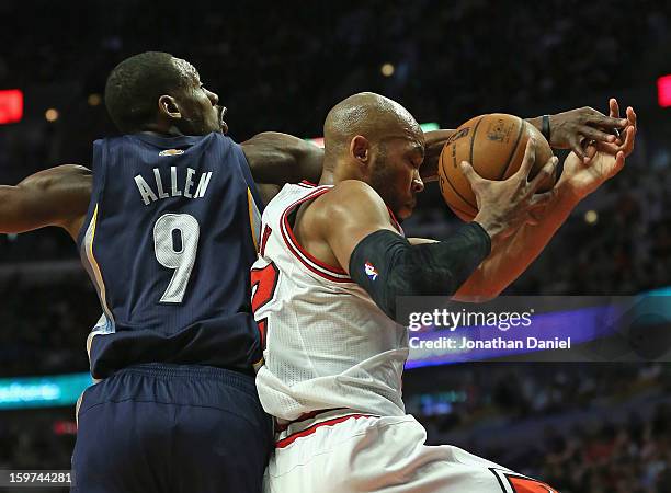 Taj Gibson of the Chicago Bulls tries to control the ball under pressure from Tony Allen of the Memphis Grizzles at the United Center on January 19,...