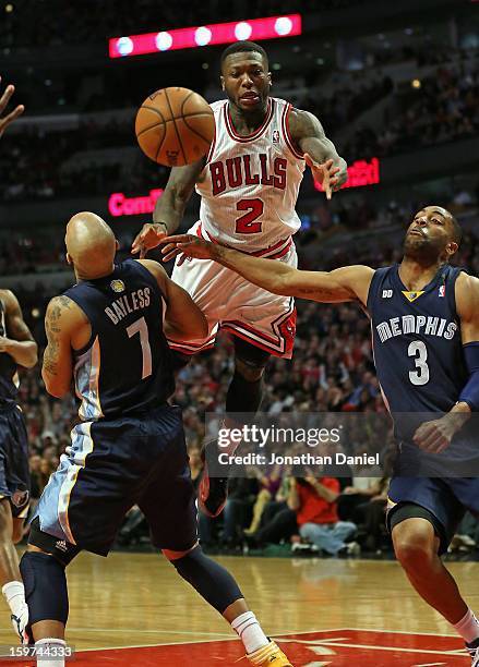 Nate Robinson of the Chicago Bulls leaps to pass between Jerryd Bayless and Wayne Ellington of the Memphis Grizzles at the United Center on January...