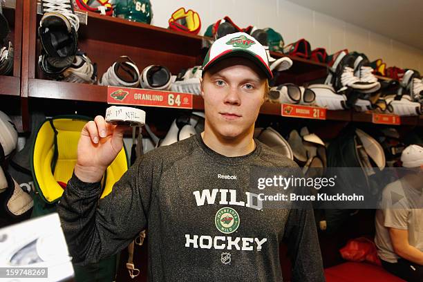 Mikael Granlund of the Minnesota Wild holds up the puck from his first career NHL goal after the game against the Colorado Avalanche on January 19,...