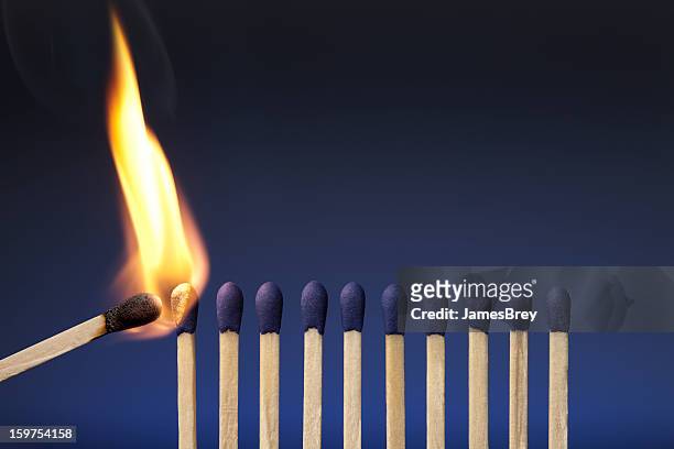 lit match next to a row of unlit matches - igniting stockfoto's en -beelden
