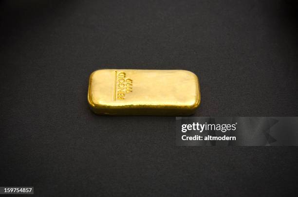 bar of gold on a black background - gold bullion stock pictures, royalty-free photos & images