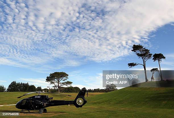 This general view shows a helicopter parked on the outer grounds outside the mansion of Megaupload founder Kim Dotcom before the launch of his new...