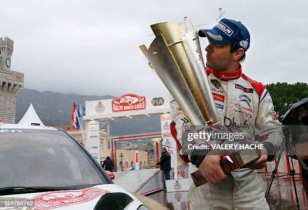 French driver Sebastien Loeb poses with his trophy a day after winning the Monte-Carlo rallye race, opening stage of the World Rally Championship, on...