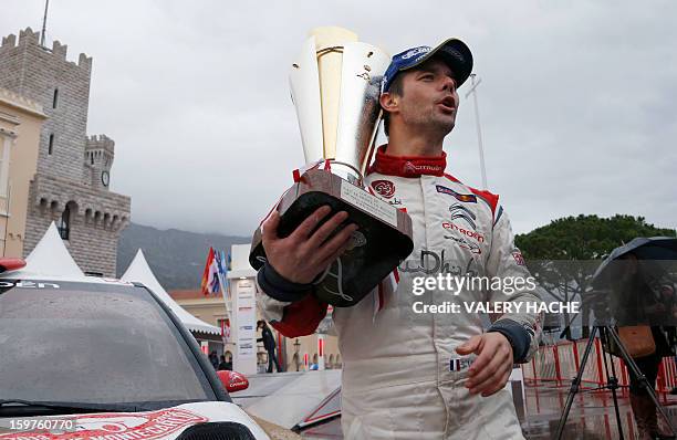French driver Sebastien Loeb poses with his trophy a day after winning the Monte-Carlo rallye race, opening stage of the World Rally Championship, on...