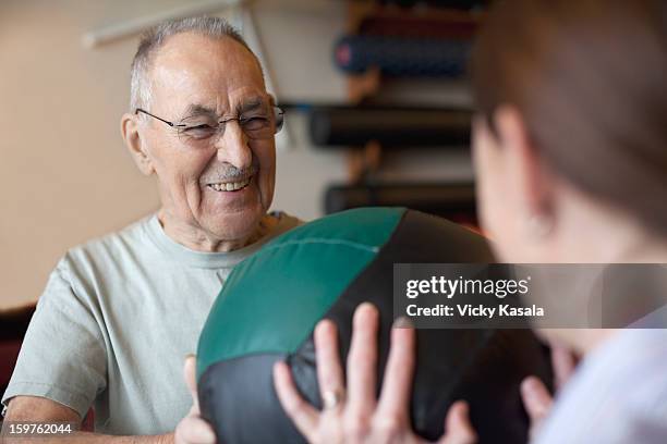 mature man exercising with physical therapist. - focus on sport 2013 stockfoto's en -beelden