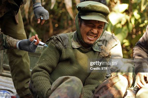 An injured rebel Kachin Independence Army 3rd Brigade soldier gets an injection from a medic on Hka Ya mountain in Kachin province on January 20,...