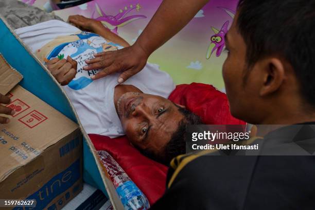Local resident Syamsuri is evacuated by Indonesian Army as major floods hit North Jakarta on January 20, 2013 in Jakarta, Indonesia. The death toll...
