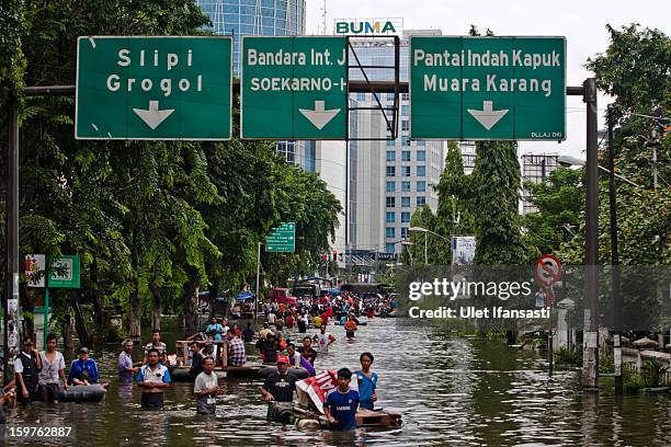 People make their way through floodwaters as major floods hit North Jakarta on January 20, 2013 in Jakarta, Indonesia. The death toll has risen to at...