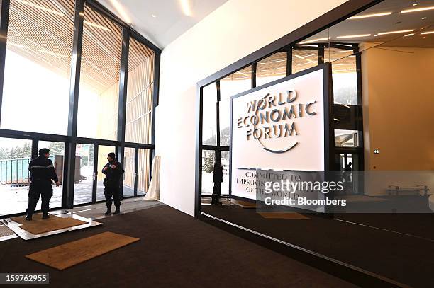 Security guards stand in the entrance to the Congress Centre alongside a giant logo for the World Economic Forum ahead of the meeting in Davos,...