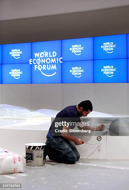 Worker paints the stage inside a hall as they prepare the Congress Centre ahead of the World Economic Forum meeting in Davos, Switzerland, on Sunday,...