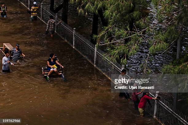 People make their way through floodwaters as major floods hit North Jakarta on January 20, 2013 in Jakarta, Indonesia. The death toll has risen to at...