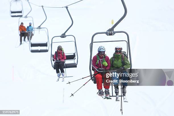 Skiers sit and travel on the Schatzalp chair lift as it moves up a mountain in the town of Davos, Switzerland, on Saturday, Jan. 19, 2013. Next week...