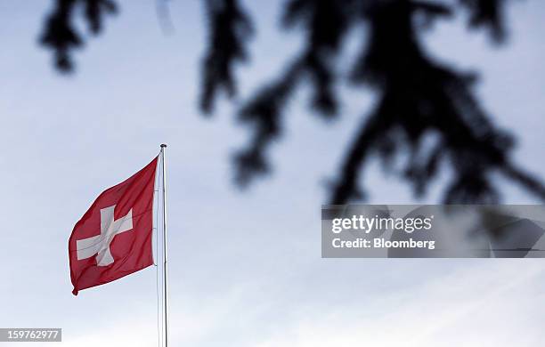 The Swiss national flag is seen flying from a flagpole at a hotel in the town of Davos, Switzerland, on Saturday, Jan. 19, 2013. Next week the...