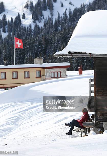 Woman sits outside a mountain hut at the top of the Schatzalp funicular railway in the town of Davos, Switzerland, on Saturday, Jan. 19, 2013. Next...