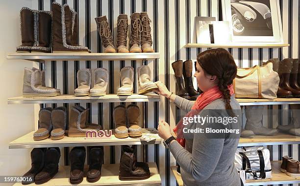 Shop assistant is seen arranging a footwear display in the Allenbach clothes store in this arranged photograph in the town of Davos, Switzerland, on...