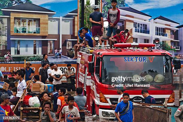 People gather around a stranded fire engine as major floods hit North Jakarta on January 20, 2013 in Jakarta, Indonesia. The death toll has risen to...